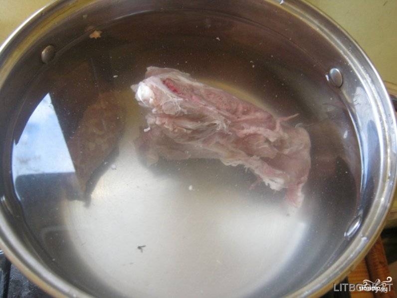 Свинину на косточке промойте. Если кусок крупный, то разрежьте его на части. Залейте мясо 1,5 литрами воды и поставьте на огонь. Варите бульон, время от времени снимая шумовкой пену, которая будет образовываться на поверхности.