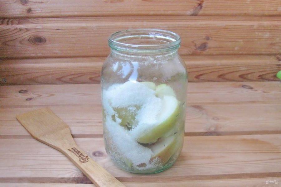 После воду слейте в кастрюлю и снова доведите до кипения. Пока вода закипает, добавьте в банку с яблоками сахар.