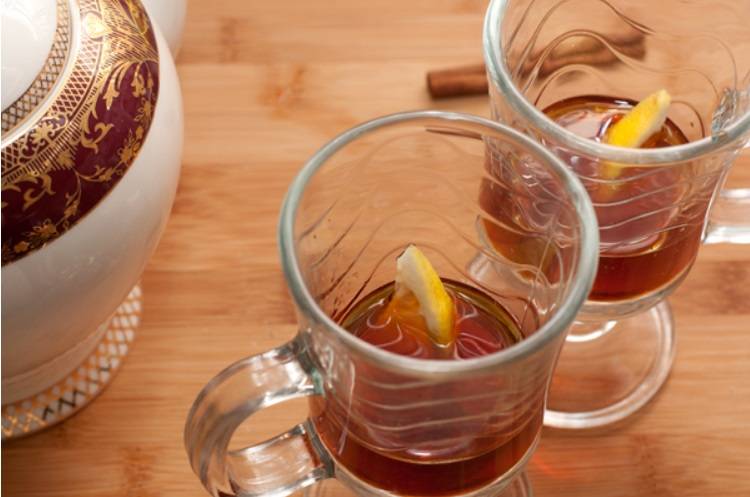 В стаканы наливаем ром, кладем по дольке лимона и наливаем процеженный чай.