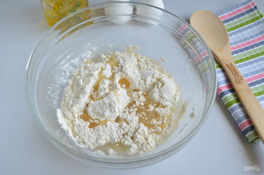 Влейте растительное масло, всыпьте муку и замесите мягкое и пластичное тесто.