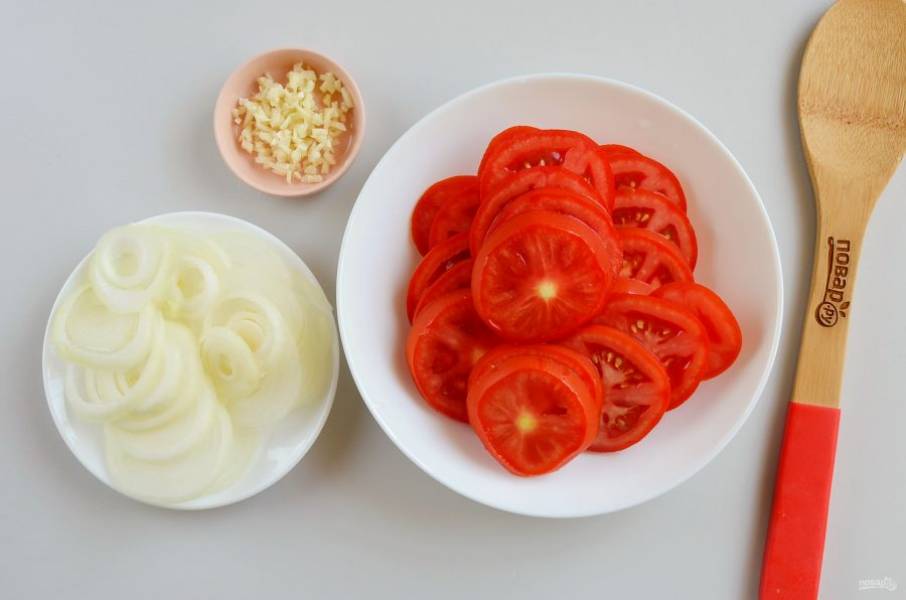 Порежьте помидоры колечками, толщина 5 мм., лук кольцами чуть тоньше, чеснок мелко порубите ножом.