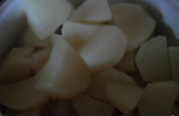 2. Чистим картофель, нарезаем его на 4 части, заливаем водой и ставим на огонь. После закипания солим, но не пересаливаем, поскольку тушенка также приправлена по вкусу.