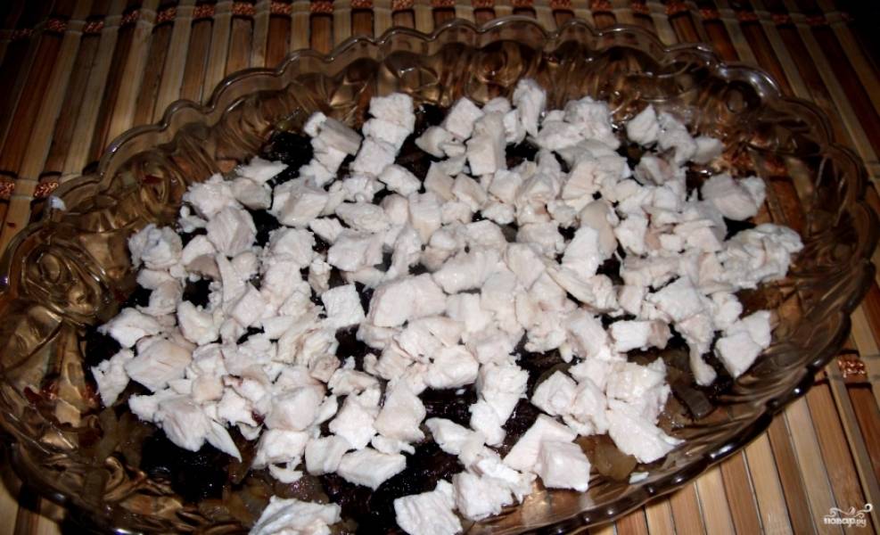 2.	Куриную грудку отвариваем в подсоленной воде, после чего нарезаем ее небольшими кусочками и выкладываем на лук с грибами.