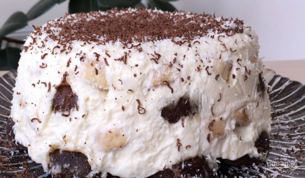 8. Переверните торт на большое блюдо, присыпьте его сверху кокосовой стружкой и тертым шоколадом. Торт готов, приятного аппетита!