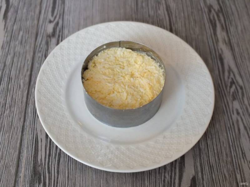Яйцо натрите на мелкой терке, добавьте 1,5 ст.л. майонеза. Перемешайте и выложите на слой из говядины.