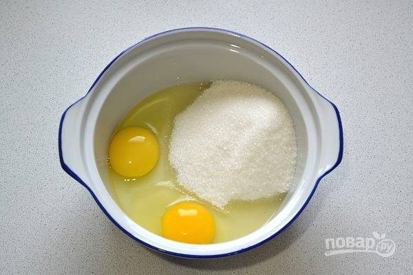 2. В небольшую кастрюльку отправьте сахар и вбейте яйца.