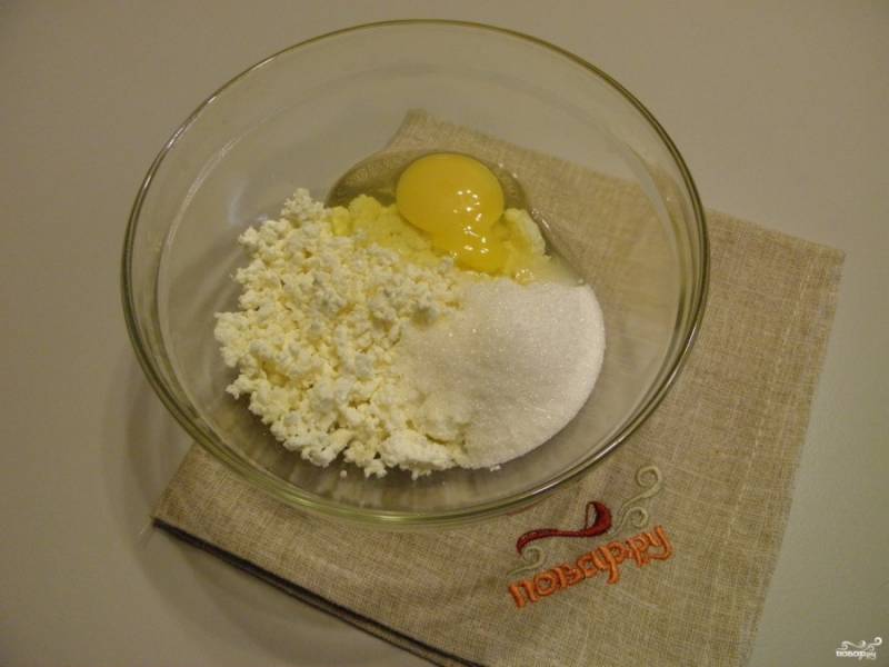 Соедините творог с сахаром и яйцом. Вилочкой разбейте крупные комочки.
