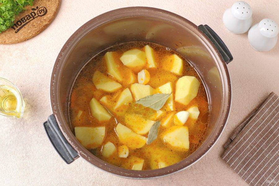 Налейте воду, чтобы она лишь покрыла картофель, добавьте лавровый лист и нарезанный пластинами чеснок. Установите режим "Тушение" и готовьте 30 минут.