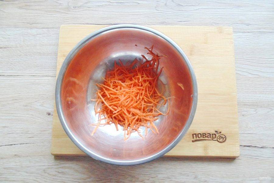 Морковь вымойте, очистите и натрите на тёрке для корейской моркови. Переложите в глубокую миску.