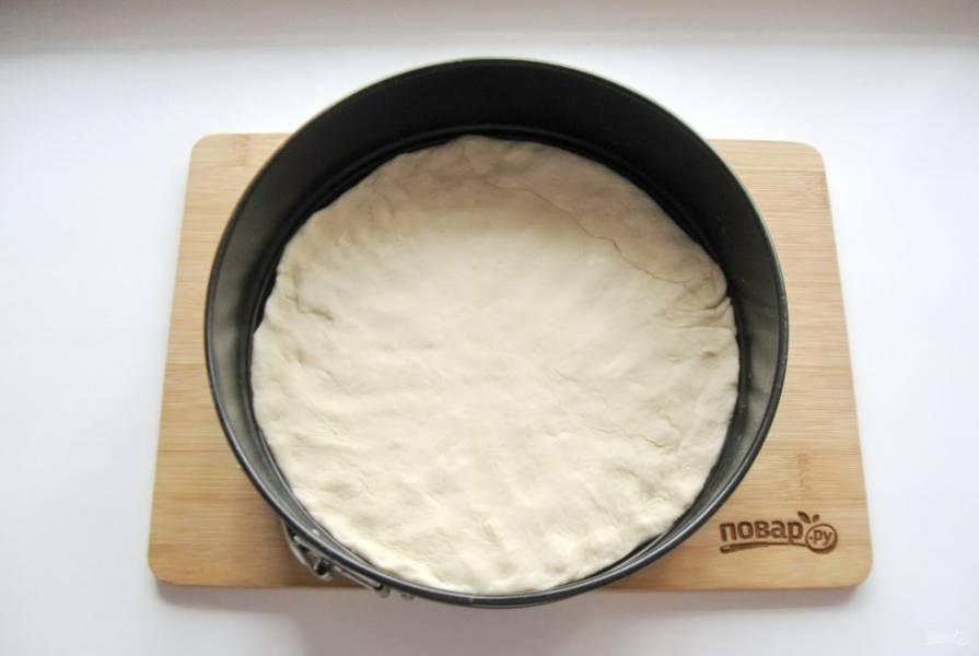 Тесто для пиццы раскатайте в пласт диаметром 26-28 см. Выложите в форму для выпекания.