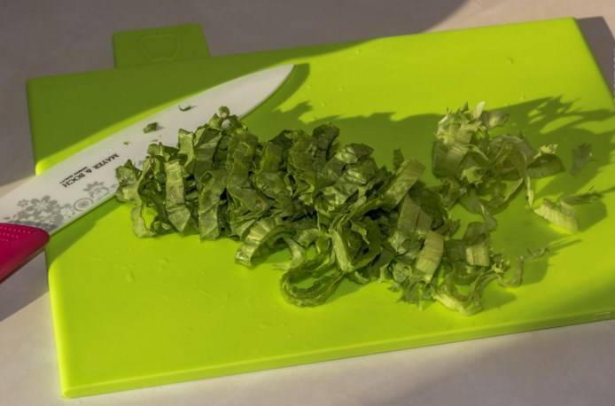 Листья зеленого салата помойте, обсушите и тонко нарежьте.