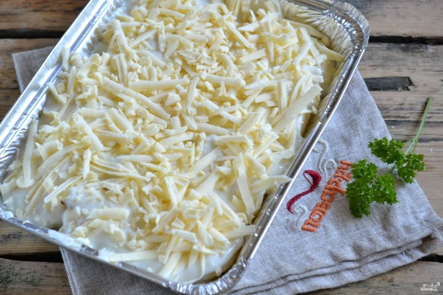 Готовым соусом залейте картошку с луком. Сверху натрите на крупной терке слой твердого сыра, отправляйте в духовку, разогретую до 200 градусов, для запекания.