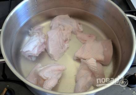 Курицу разделите на большие куски. Выложите их в кастрюлю и залейте водой.