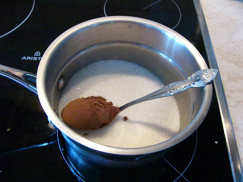 2. В небольшой сотейник насыпьте сахар, добавьте какао. Его количество зависит от ваших вкусовых предпочтений: чем больше какао, тем "шоколаднее" будет десерт. 