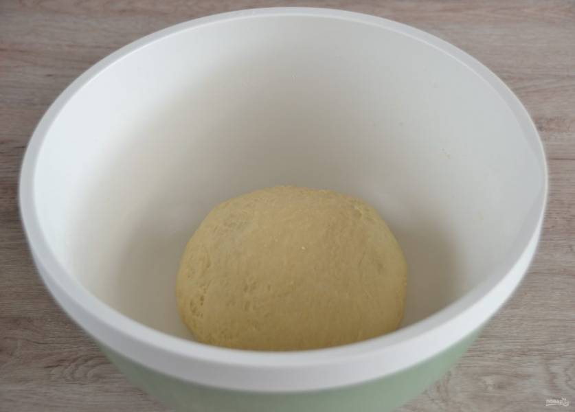 Замесите тесто, сделайте из него шар, накройте крышкой или пищевой пленкой, поставьте в теплое место для брожения на 1,5-2 часа.