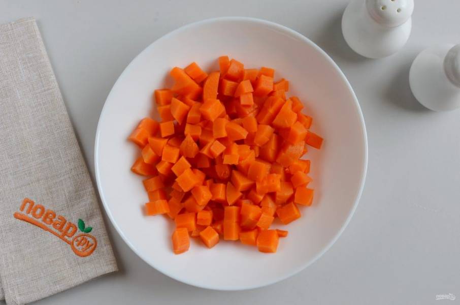 Порежьте кубиками морковь.