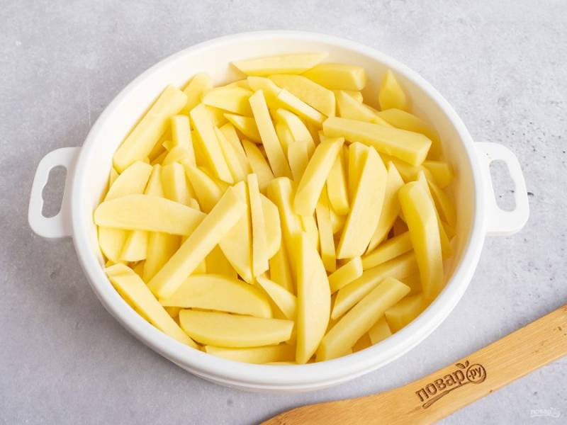 Нарежьте картофель брусочками, как и положено для фри. Затем промойте брусочки в ледяной воде 2-3 раза от крахмала. Обсушите картофель хлопковым полотенцем и выложите в удобную миску.