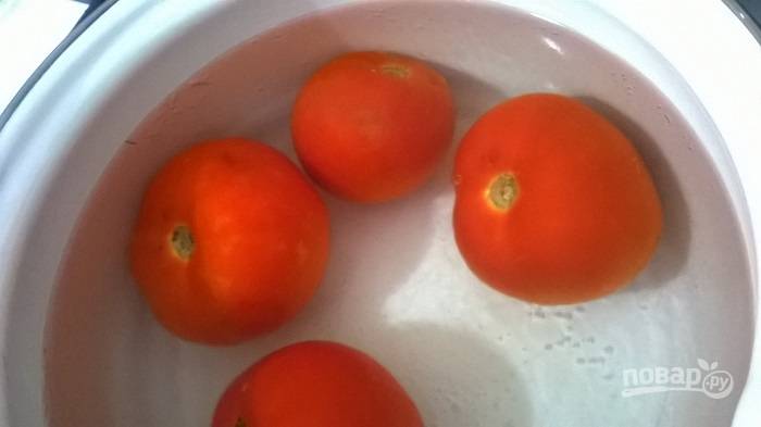 1.	Вымойте томаты и выложите их на стол. В кастрюле вскипятите воду и выключите огонь, поместите помидоры в кипящую воду на 1-2 минуты.