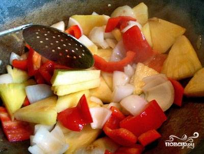 6. В глубокой сковороде разогрейте 70 граммов растительного масла. В кипящее масло положите все овощи вместе с кусочками ананаса. Быстро помешивая, обжарьте на большом огне 5 минут.
