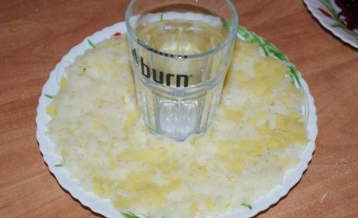 Вокруг стакана выкладываем слой картофеля.