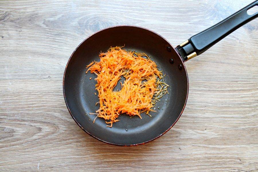 Морковь почистите и натрите на средней терке. В другую сковороду налейте растительное масло  и добавьте морковь.