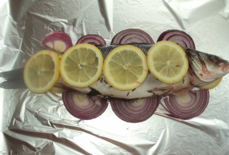 Фольгу слегка смазываем маслом, выкладываем лимон, потом лучок - сверху рыбу. На рыбу еще лук и лимон. 