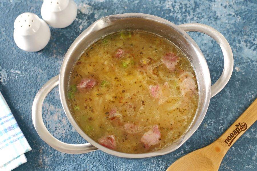 Суп посолите, поперчите, добавьте в кастрюлю содержимое сковороды и доведите до кипения. Буквально через пару минут, снимите с огня и дайте слегка настояться. Затем разлейте гороховый суп по тарелкам и подавайте к столу.