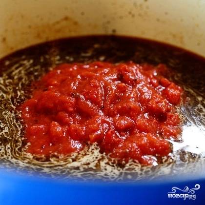 В ту глубокую сковороду или кастрюлю, где обжаривалось мясо, вливаем говяжий бульон и добавляем перетертые помидоры.