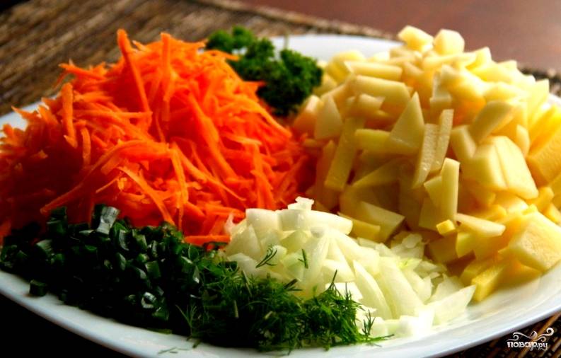 Пока курица варится, подготовим овощи. Нарежем картофель, лук и зелень. Морковь потрем на терке.