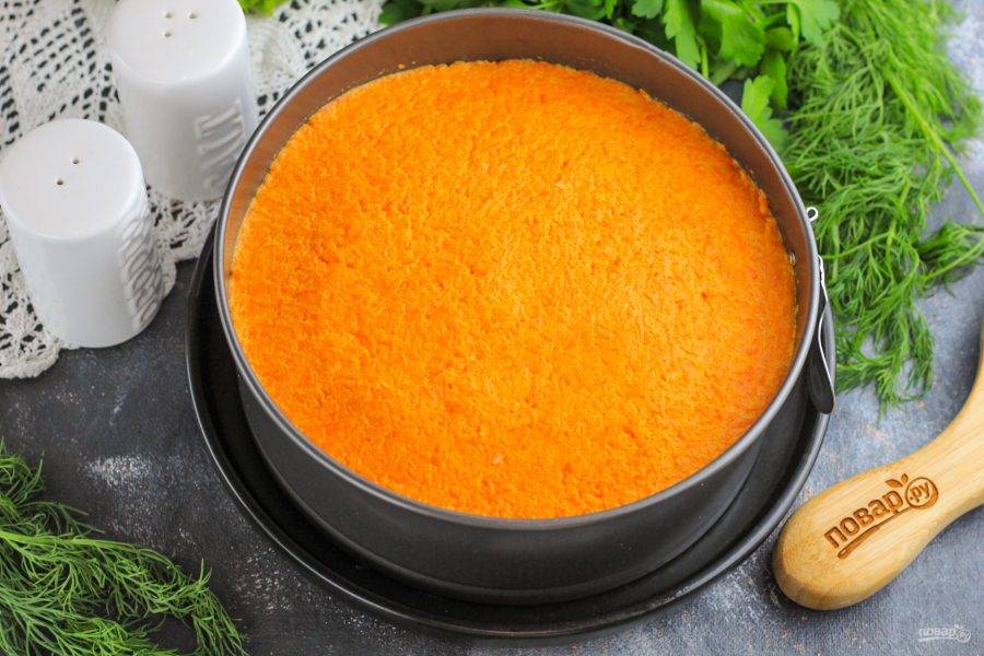 Выложите морковный слой. Если его окажется много, то добавьте часть морковной нарезки в желтковую массу.