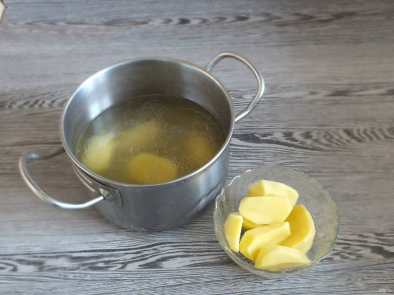 В кастрюлю с бульоном опустите картофель разрезанный пополам. Поставьте на огонь и варите до готовности картофеля.