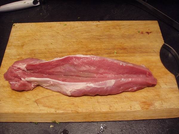 1. Итак, подготовьте кусочек свинины, вымойте его как следует и обсушите бумажной салфеткой. Острым ножом сделайте разрез так, чтобы образовалась полость для начинки. Подсолите немного мясо со всех сторон, при желании добавьте перец. Еще отлично подойдет пропущенный через пресс или молотый чеснок. 