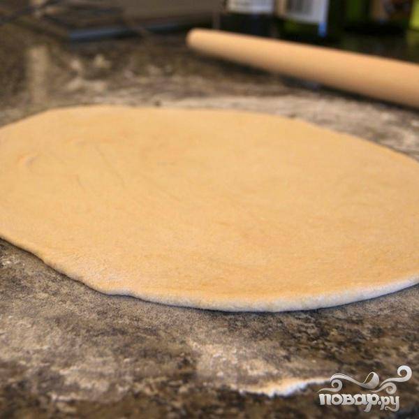 Нагреть духовку до 220 градусов. На хорошо присыпанной мукой поверхности стола, раскатать тесто в большой тонкий круг. Выложить корж на лист для выпечки или противень, запекать в течении 5 минут.