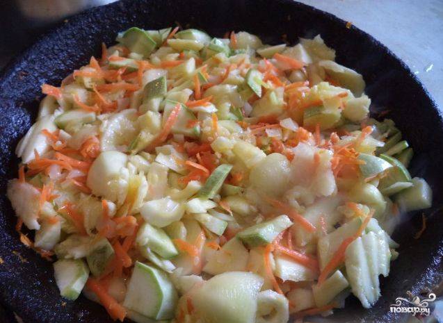 Прогрейте сковородку, налейте на неё растительное масло. Высыпьте нарезанные кабачки, лук и тёртую морковку. Перемешайте овощи, протушите их в течение 30-40 минут. Не забывайте помешивать время от времени.
