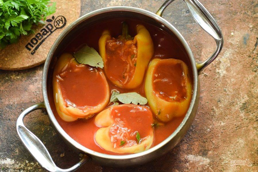 Выложите перцы в кастрюлю, залейте томатным соком и соевым соусом, добавьте лавровый лист.