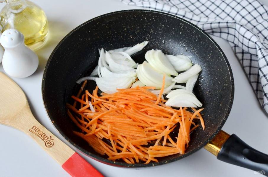 Нарежьте полукольцами лук, морковь натрите на крупной терке. Обжарьте овощи на растительном масле несколько минут.