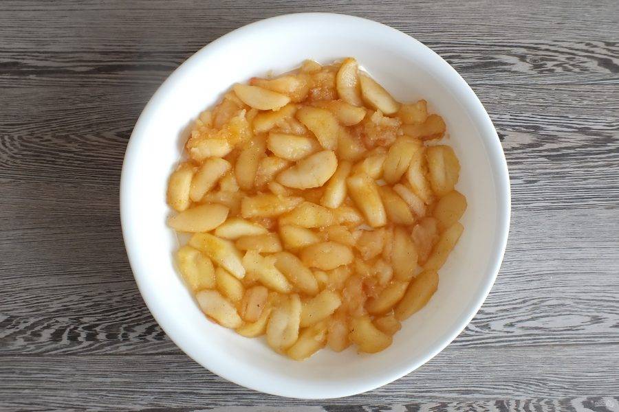 Возьмите форму для выпечки. Смажьте ее тонким слоем сливочного масла. Выложите обжаренные яблоки.