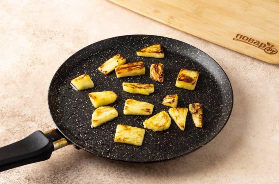 Ананас нарежьте ломтиками толщиной 0,5 см., смажьте растительным маслом и обжарьте на сковороде пару минут до румяного цвета. Также можно для этого использовать гриль.