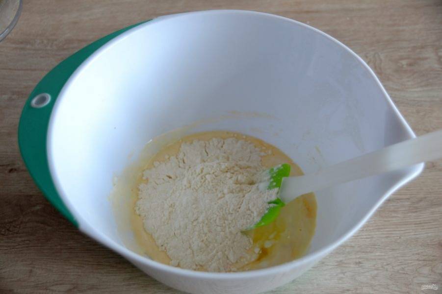 Всыпьте к яично-сметанной смеси  щепотку соли, муку и разрыхлитель, постепенно вмешивая в тесто. 