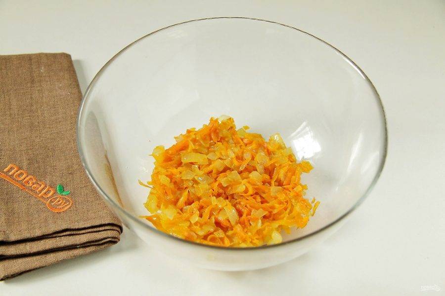 Лук нарежьте кубиками. Морковь натрите на терке. Обжарьте лук с морковью на сковороде до готовности и переложите в глубокую миску или салатник.