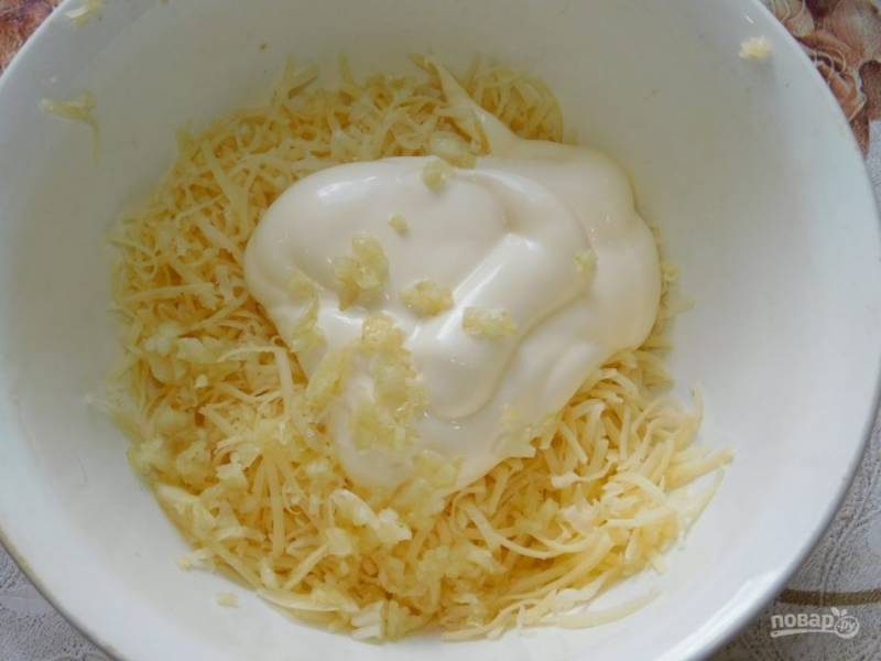 Отдельно смешайте тертый сыр, измельченный чеснок и майонез.