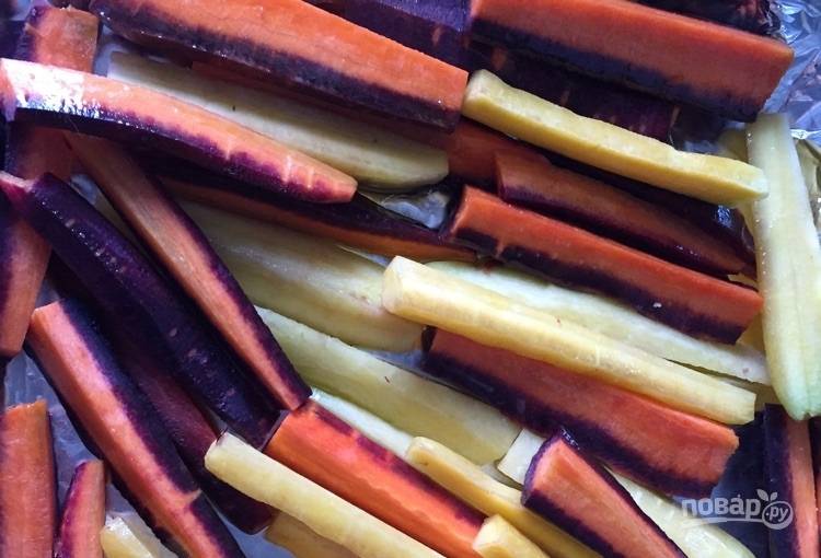 1.	Очистите морковь, разрежьте ее вдоль на несколько полосок. Выложите морковь на противень, полейте 2 столовыми ложками оливкового масла, посолите и отправьте противень в разогретый до 180 градусов духовой шкаф на 30 минут.