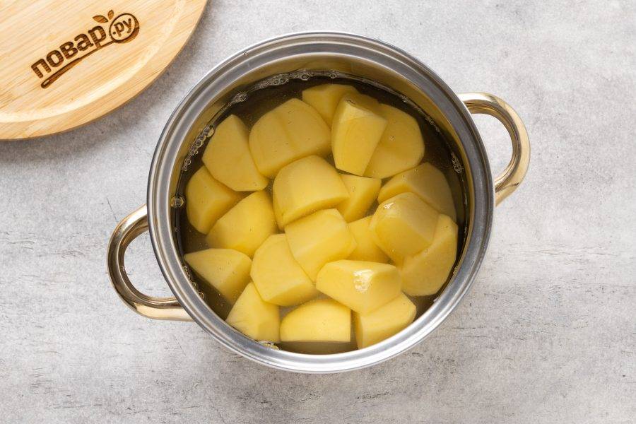 Картофель промойте, очистите от кожуры и нарежьте ломтиками. Отварите до мягкости в кипящей подсоленной воде.