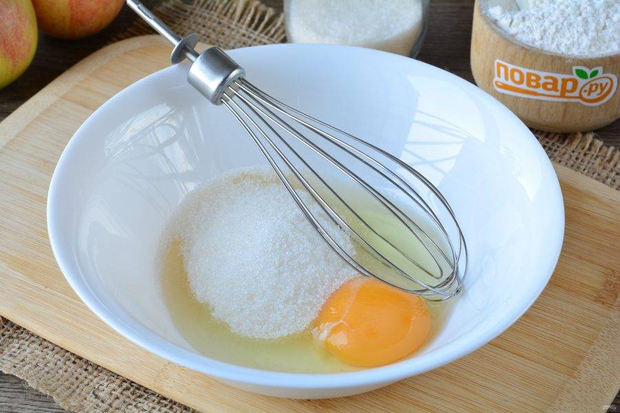 Вбейте в миску яйца и всыпьте сахар, хорошо взбейте венчиком.