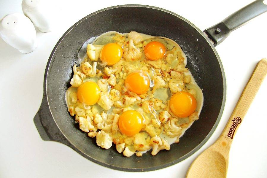 К капусте в сковороду вбейте яйца. Посолите и жарьте без крышки на среднем огне до желаемой степени готовности яиц. Если желаете яичницу "мешанку", то яйца предварительно разбейте в миску, взбейте с солью, а затем уже вылейте на капусту.