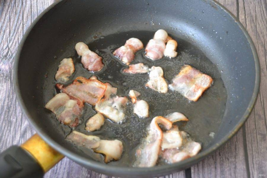 На сковороду выложите копченое сало или жирный бекон. Если их нет, можно заменить на растительное масло. Сало необходимо вытопить, выжарки убрать.