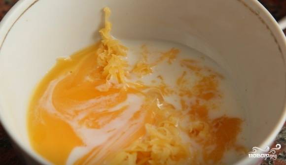 В миске взбейте желток со сливками и натёртым сыром. Второе яйцо отварите вкрутую и, когда остынет, натрите его на терке.