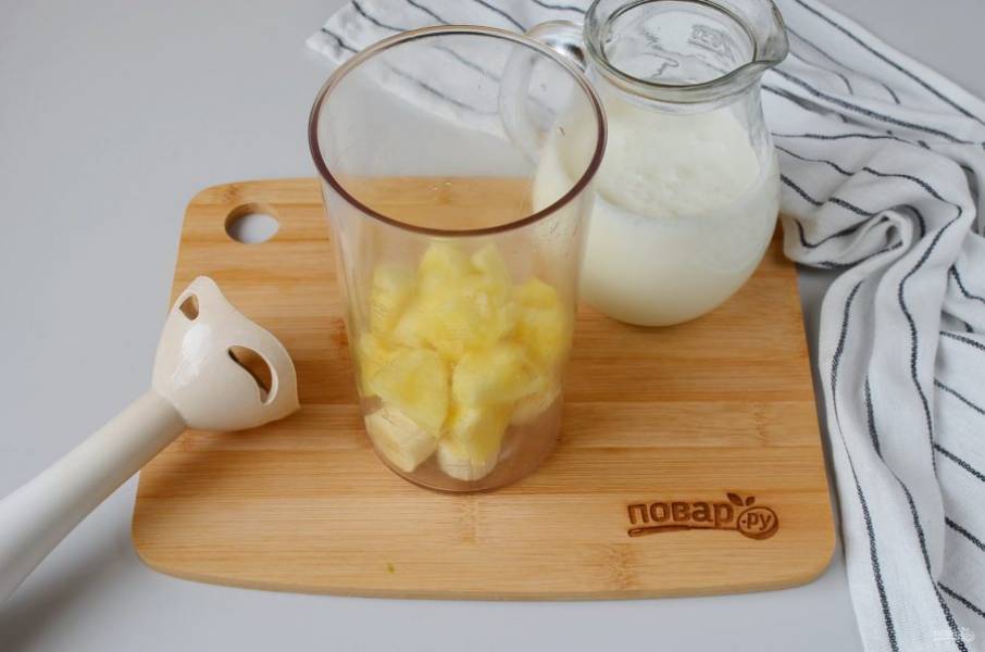 Очистите от кожуры ананас, удалите волокнистую сердцевину, порежьте кусочками. Очистите банан и нарежьте. Сложите фрукты в чашу блендера (подойдет стационарный или погружной блендер). Добавьте мед.