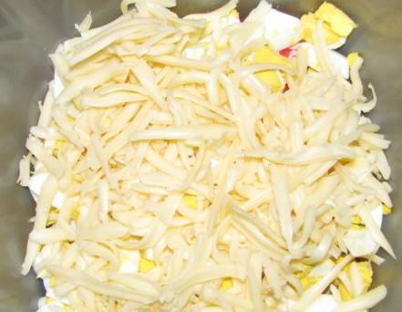 Натираем на терке сыр, добавляем в салатницу.