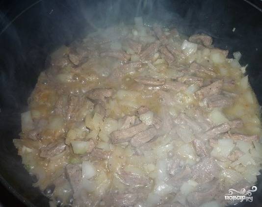 6. На сковороду к мясу добавить лук и чеснок. Хорошо перемешать и жарить минимум 5 минут.